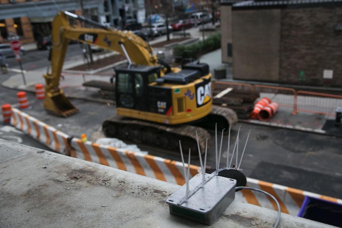 挖掘机在工地作业的街道附近的噪音传感器。