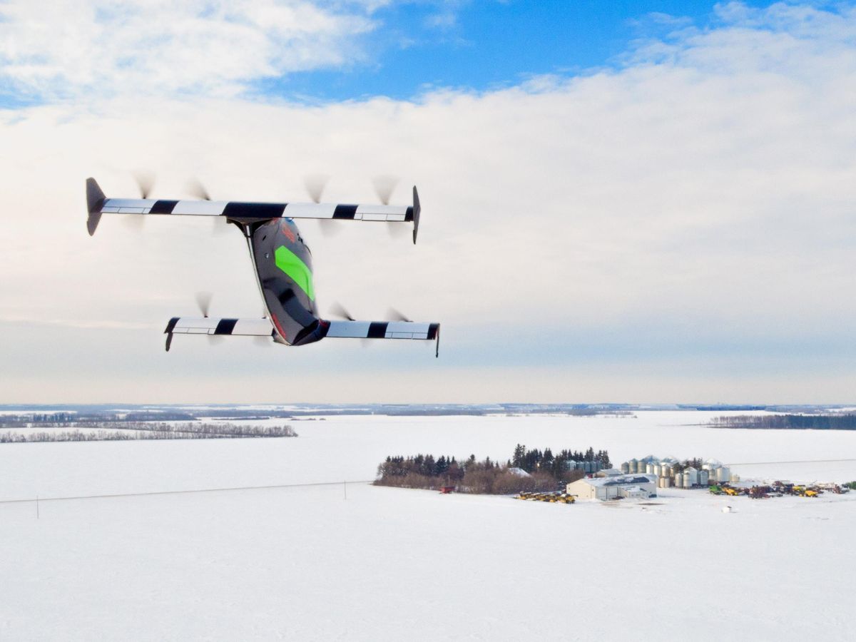 一架拥有两个机翼和八个螺旋桨的不同寻常的飞机在白雪覆盖的平原上飞行。