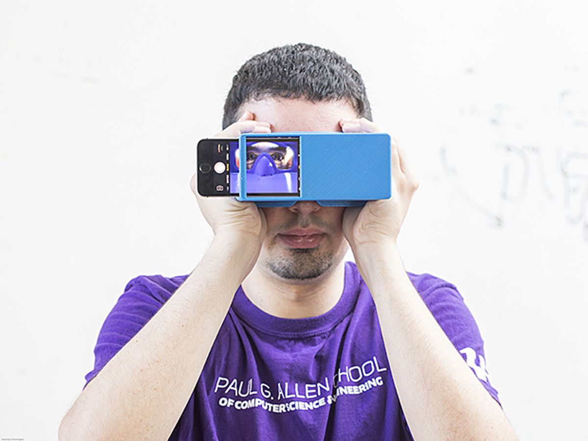 图片:一个人拿着一个装有智能手机摄像头的盒子，对着自己的脸自拍自己的眼睛，通过一款新的应用程序来检测胰腺癌的早期迹象